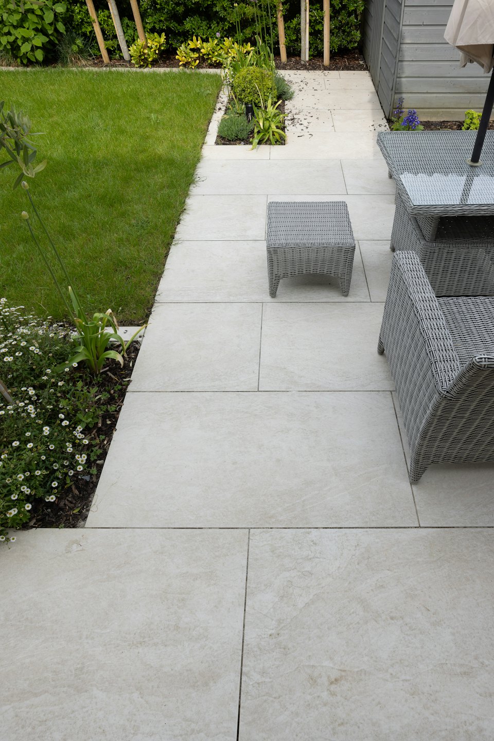 Moderne Terrasse mit Gartenmöbeln und grünem Rasen.